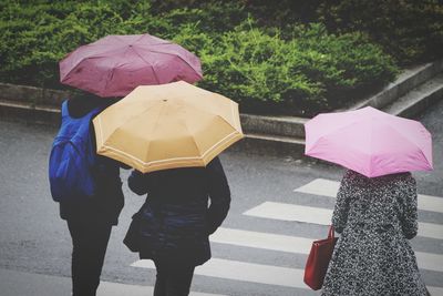 Rear view of people walking on wet street