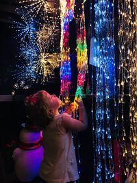 Cute girl holding illuminated christmas lights