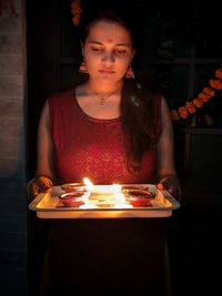 Portrait of smiling young woman sitting on table