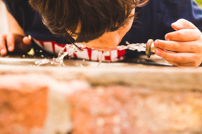 Close-up of man holding ice cream on wood