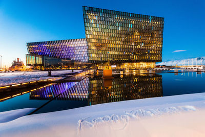 Digital composite image of illuminated building against clear sky