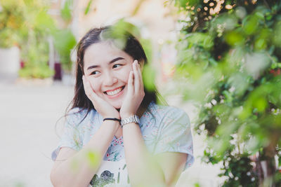 Smiling woman looking away by plants