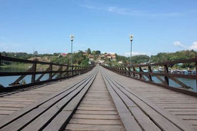 Footbridge over river against sky