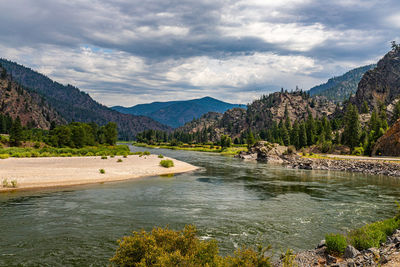 Scenic view of river and mountains against sky