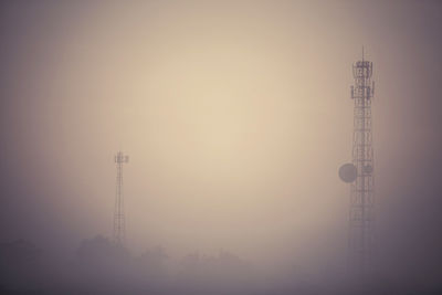 Low angle view of communications tower against sky during sunset