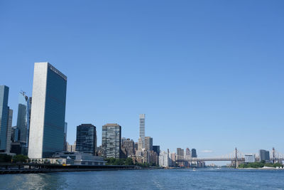 Buildings in city against clear blue sky