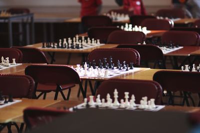 Chess on table amidst chairs