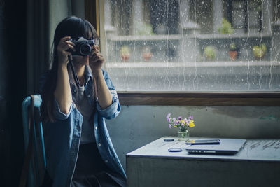 Young woman with flowers in vase