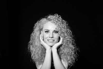 Portrait of a smiling woman against black background