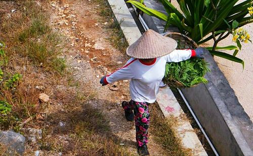 Rear view of woman walking with umbrella