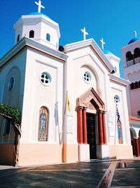 Low angle view of church against clear blue sky during sunny day