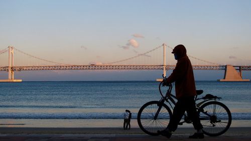 People on bridge at sunset