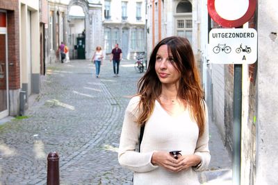 Young woman using mobile phone in city
