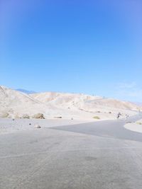 Scenic view of desert against clear blue sky