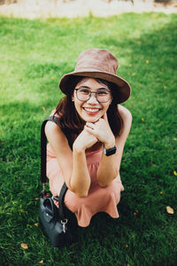 Portrait of young woman sitting on grassy field