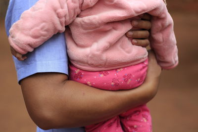 Close-up mid section of a person carrying baby