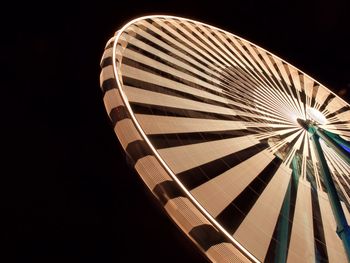 Low angle view of illuminated ferris wheel against sky