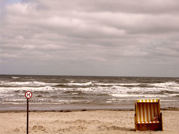 Lifeguard hut on beach against sky