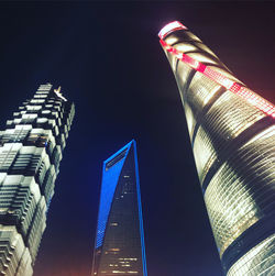 Low angle view of illuminated buildings against sky at night