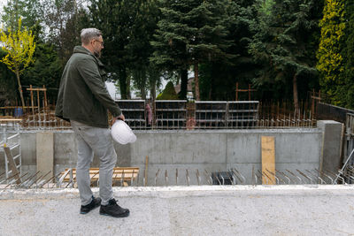 Foreman builder engineer worker looking at large building construction site sunny day hard work