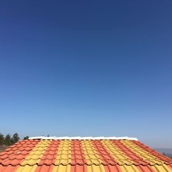 Roof tiles on house against clear blue sky