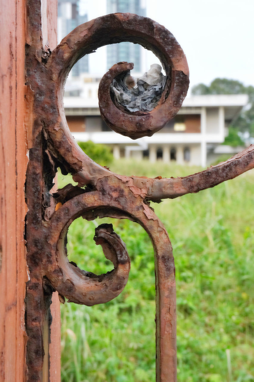 CLOSE-UP OF RUSTY CHAIN HANGING ON METAL