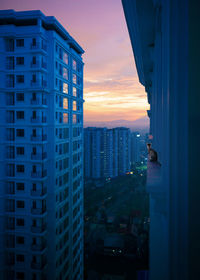 Buildings in city against sky during sunset