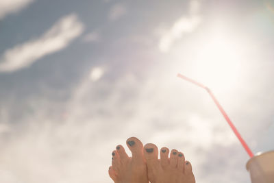 Cropped image of person holding umbrella against sky