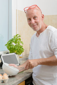 Portrait of man preparing food in kitchen at home