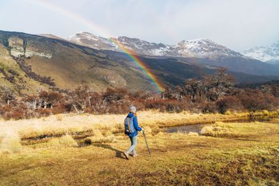 Rear view of man on field against mountains