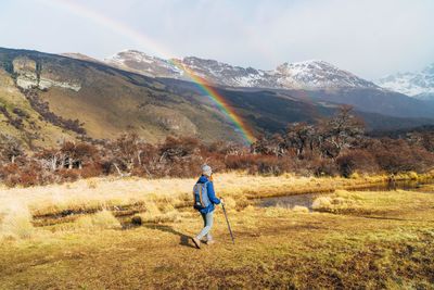 Rear view of man on field against mountains