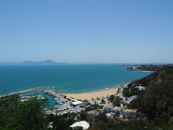 High angle view of townscape by sea against clear sky