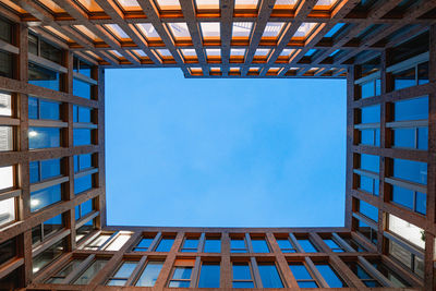 Low angle view of modern building against clear blue sky