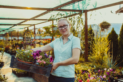 Woman standing by flowering plants