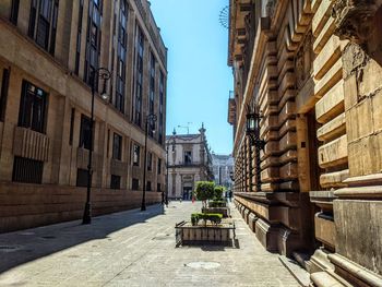 Footpath amidst buildings against sky