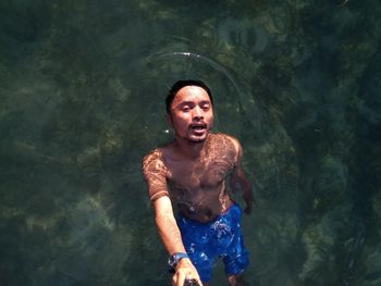 Portrait of shirtless man in swimming pool