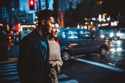 Young man standing on city street at night