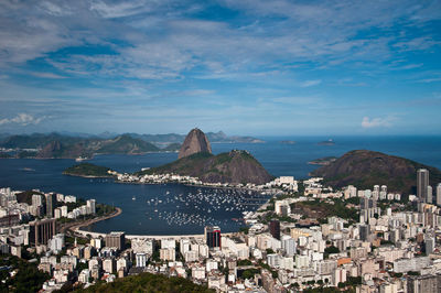 High angle view of townscape by sea against sky