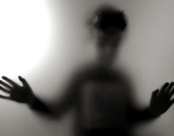 Close-up shadow of boy on frosted glass