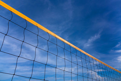 Low angle view of beach volleyball net against blue sky