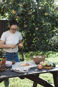 Woman in glasses picking apples from a tree and cooking a pie 