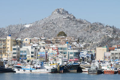 Boats moored on mountain against clear sky