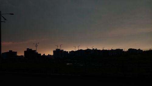 Silhouette buildings against sky during sunset