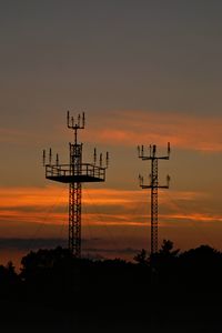 Silhouette electricity pylon against sky during sunset