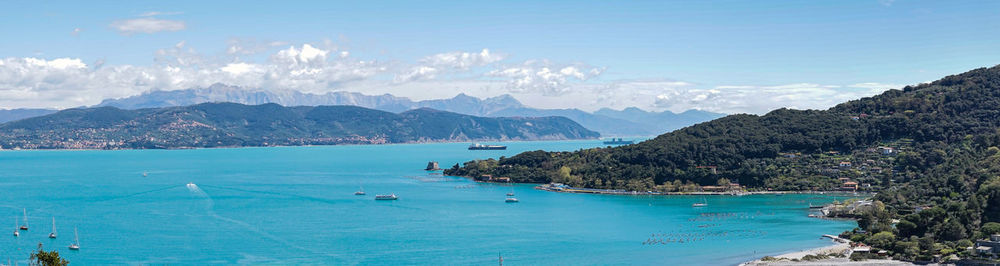 Scenic view of sea and mountains against sky