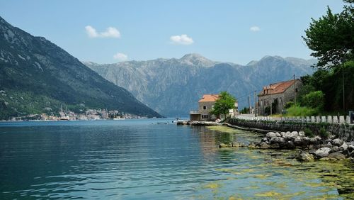 Scenic view of lake by buildings against sky