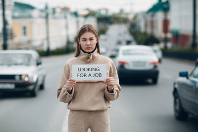 Portrait of man standing on street in city