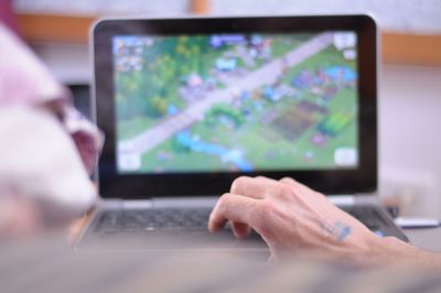 Cropped hand of man using laptop at home