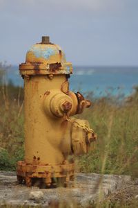 Close-up of fire hydrant on field against sky