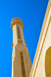 Low angle view of sheikh zayed mosque minaret against clear blue sky